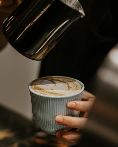 Free A barista skillfully pours perfect latte art in a Baku coffee shop. Stock Photo