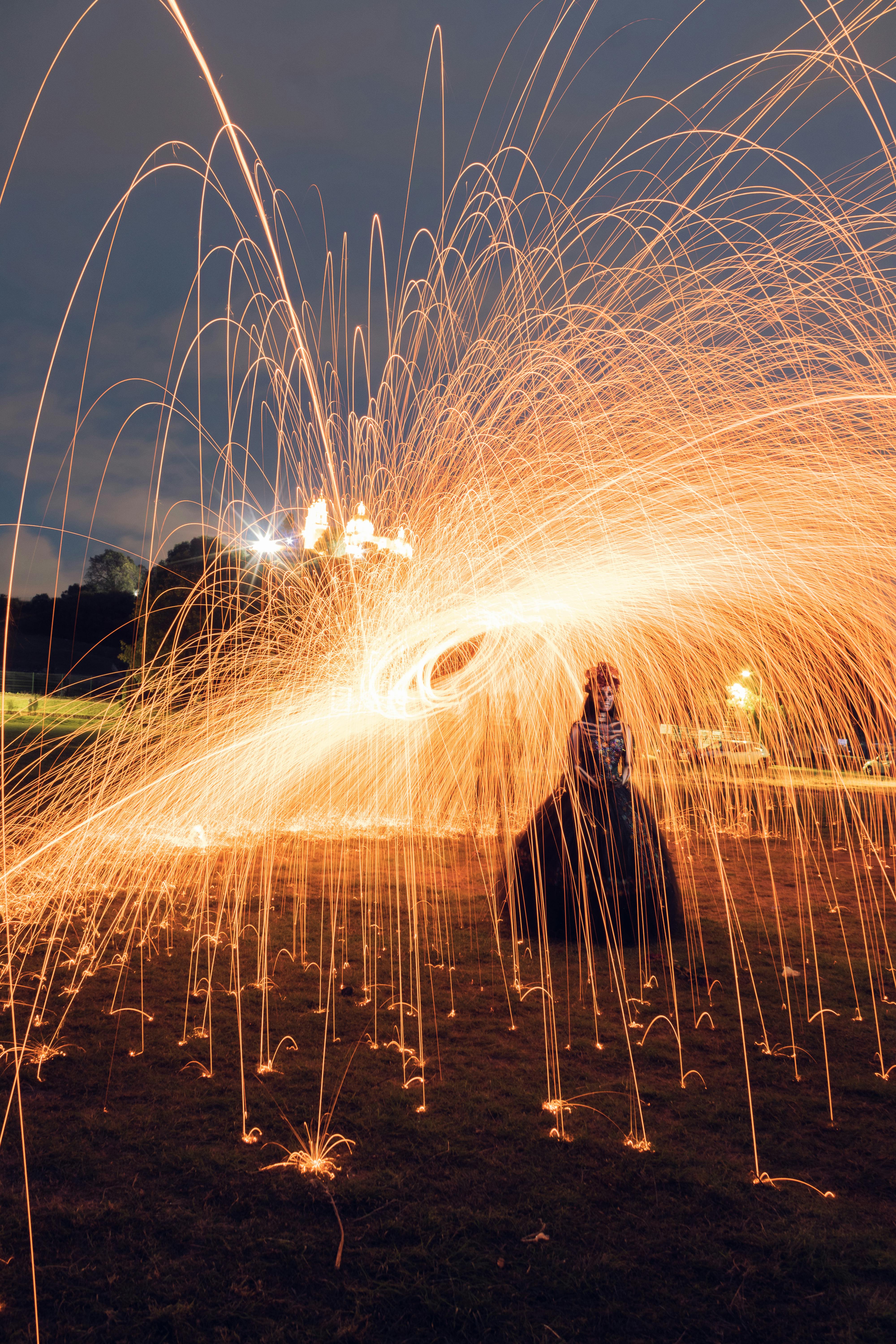 Dramatic long exposure of steel wool sparks creating a fiery spectacle at night.
