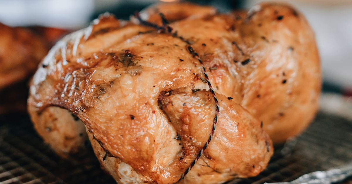 Deliciosa close-up de um frango perfeitamente assado temperado com ervas, ideal para fotografia de alimentos.