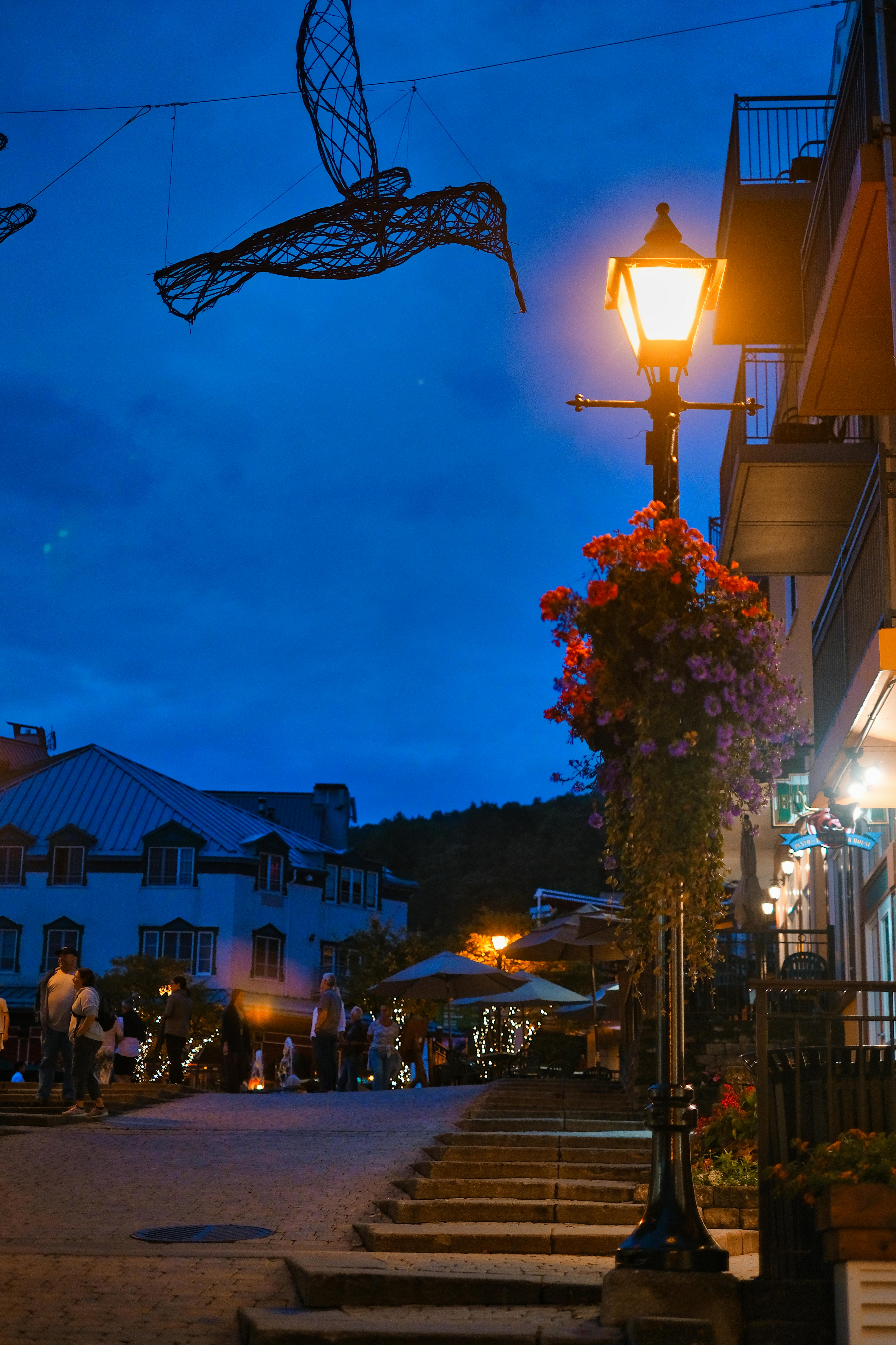 Prescription Goggle Inserts - A picturesque street with cozy lighting in Mont Tremblant during twilight.