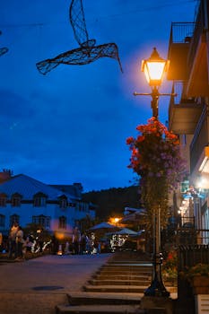 A picturesque street with cozy lighting in Mont Tremblant during twilight.
