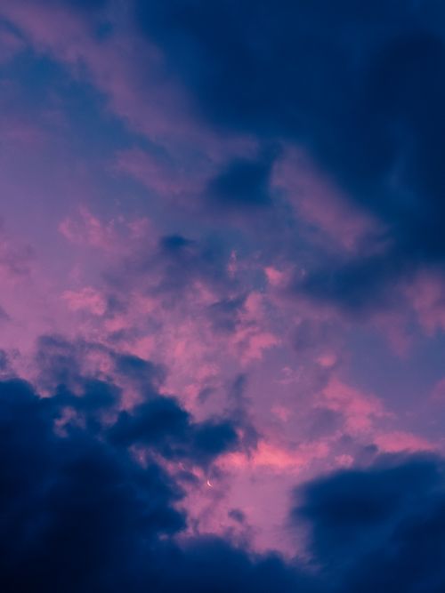 Free A beautiful and dramatic sky filled with pink and purple clouds viewed during twilight. Stock Photo