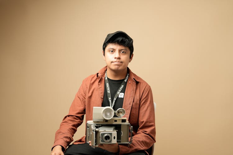 Man With Retro Camera Posing In Studio