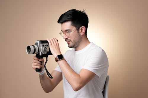 Man in White T-shirt Holding Camera