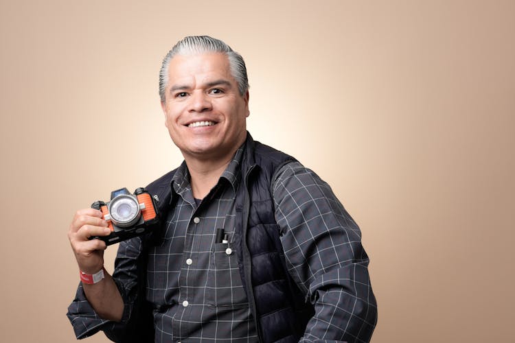 Portrait Of Smiling Man Holding Camera