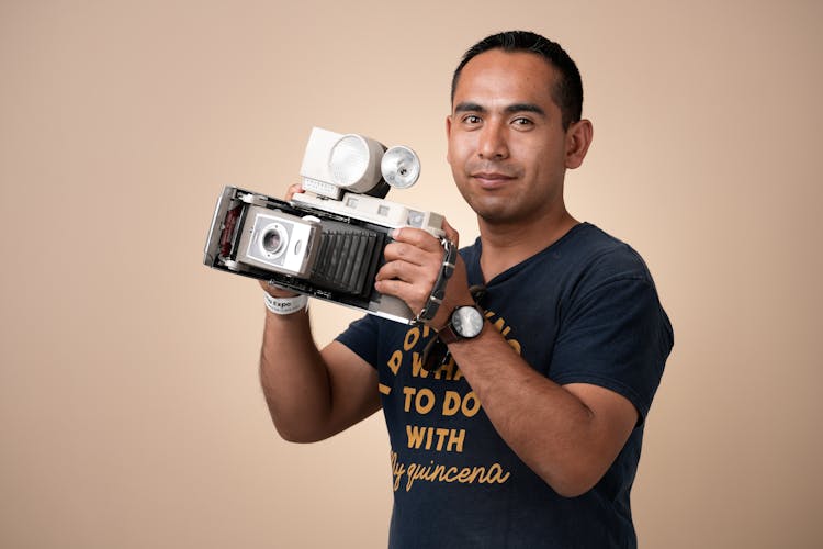 Portrait Of Man Holding Retro Camera