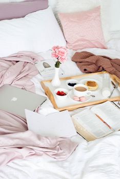 A relaxing breakfast in bed with coffee, pancakes, and fresh flowers for a perfect morning.