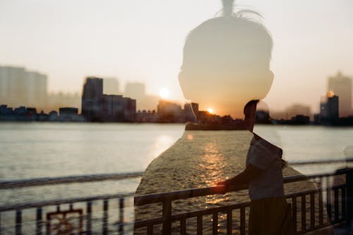 Silhouette of a Man on a Photo of a Woman Smiling on a Bridge