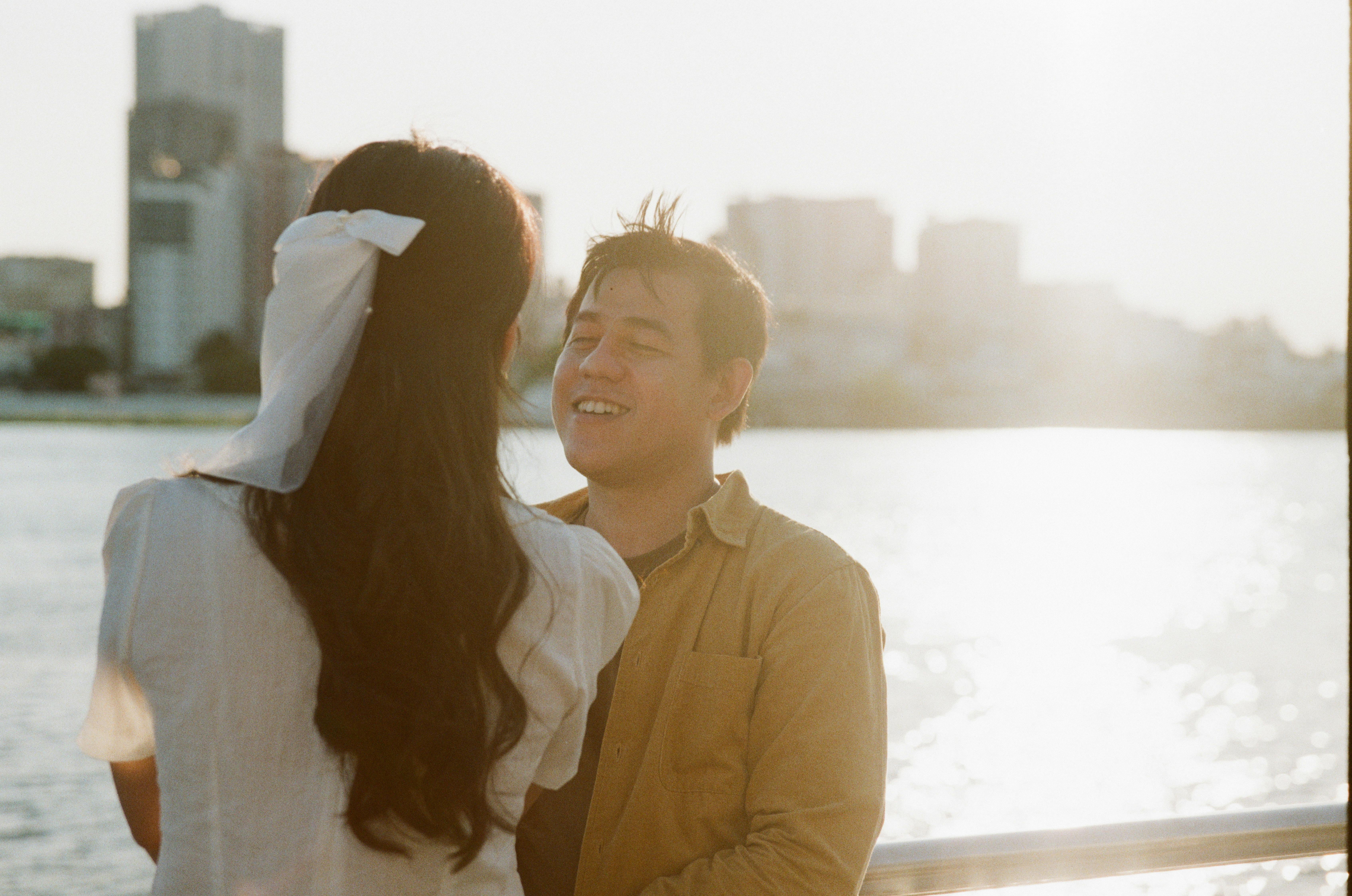 A couple enjoys a peaceful moment by the water during sunset.