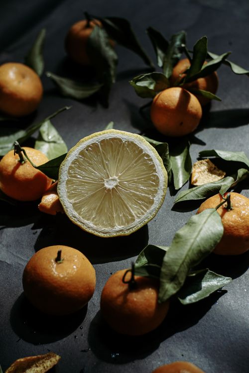 Free Top view of mandarins and a sliced lemon on dark surface, capturing a moody and organic vibe. Stock Photo