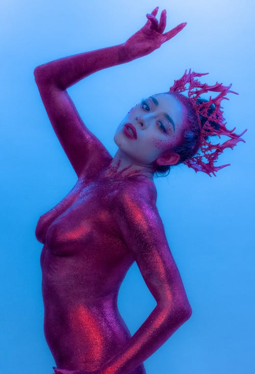 Woman in Eccentric Costume Posing on Blue Background