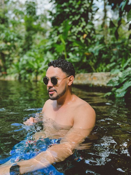 Man in Sunglasses Swimming in Water in Green Park