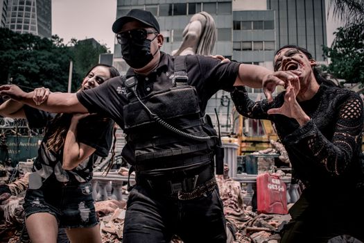 Urban apocalypse scene with people in zombie makeup and tactical gear in Mexico City.