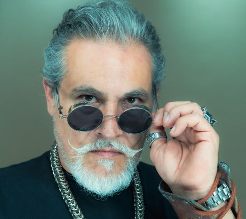 Free Portrait of a fashionable senior man with grey hair and sunglasses in a studio setting. Stock Photo