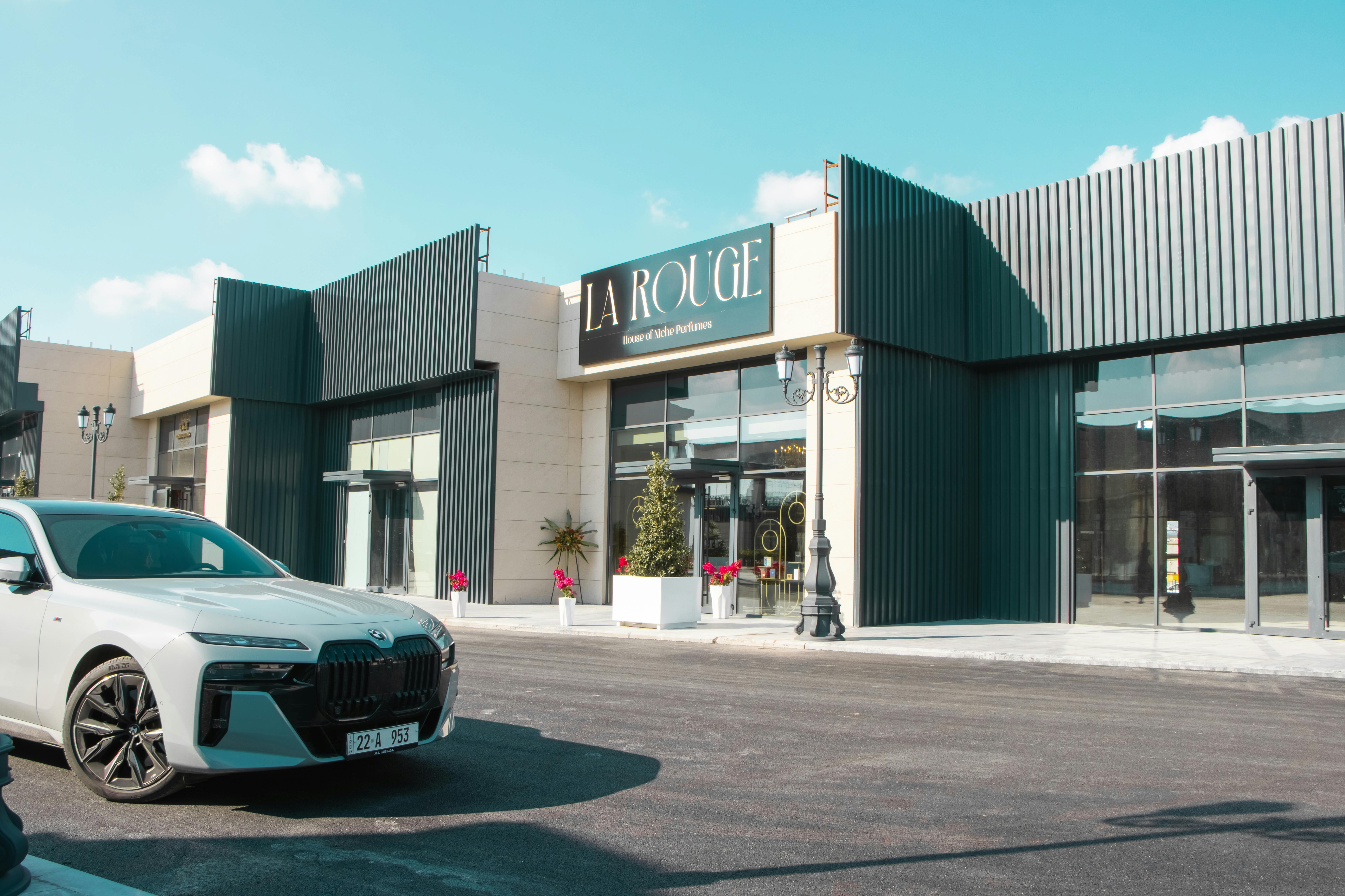 bmw m760e parked in front of la rouge perfume boutique