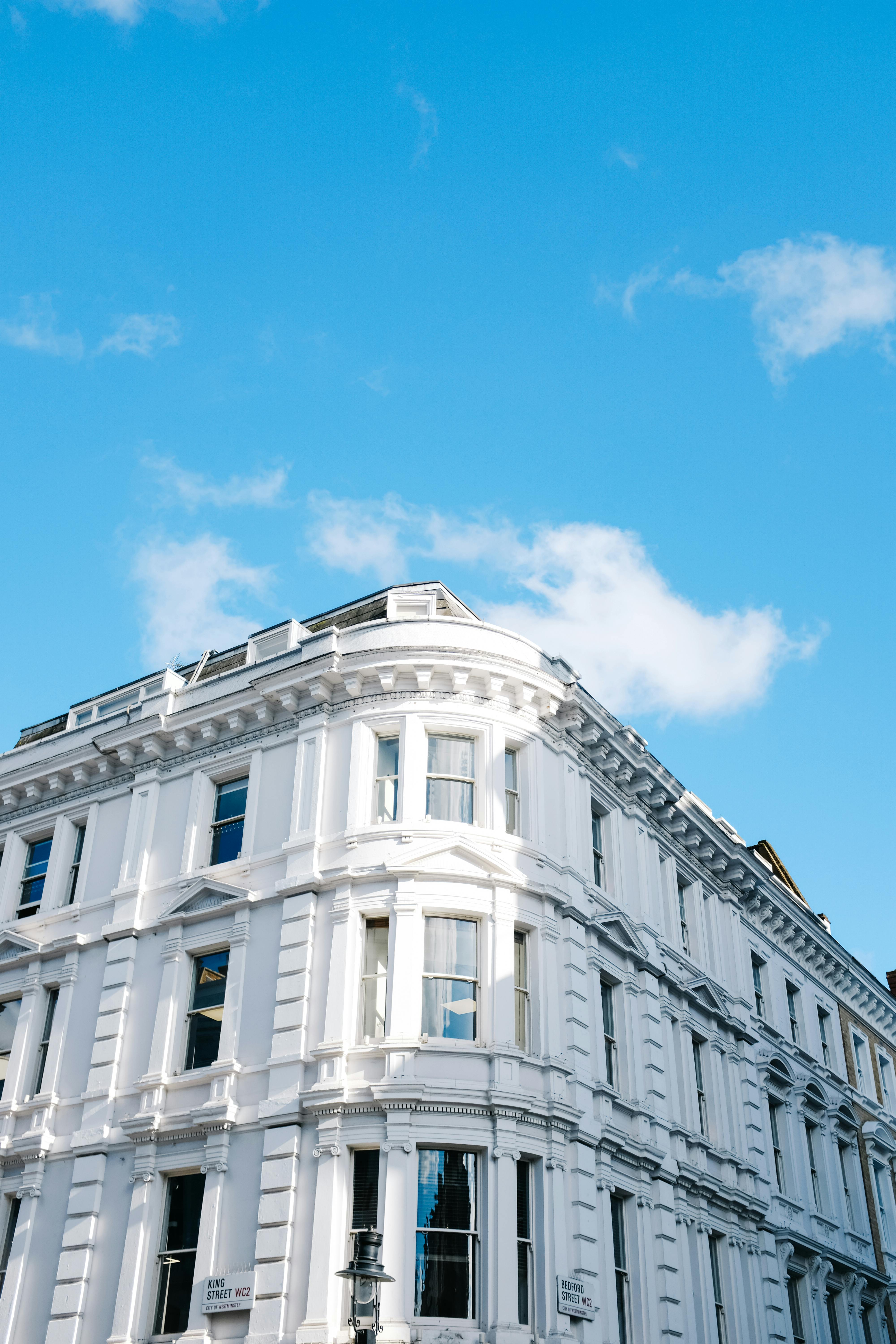 A classic architectural structure with white exterior set against a vibrant blue sky, showcasing urban elegance.