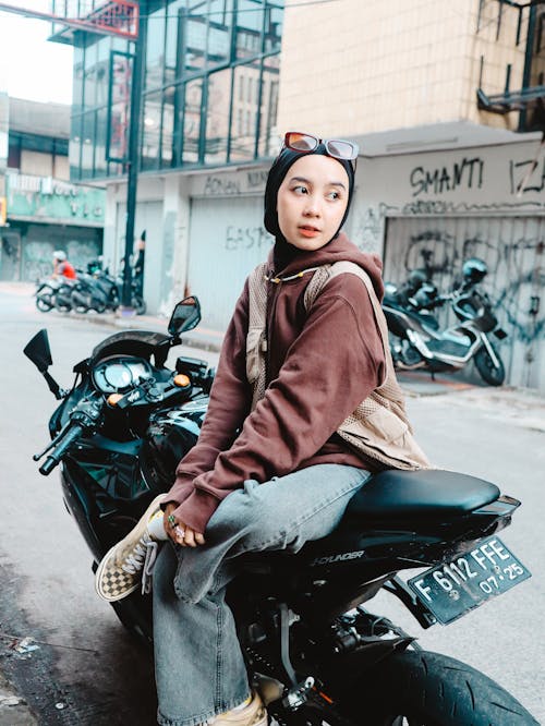 Woman in Hijab Sitting on Motorcycle