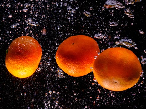 Fresh tangerines splashing underwater with bubbles highlighting their vibrant color and texture.