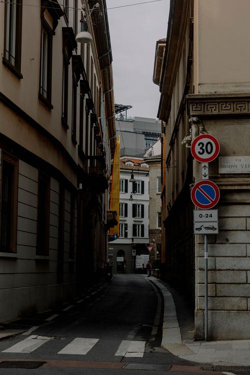 Free A narrow urban alley with historic buildings and street signs. Stock Photo