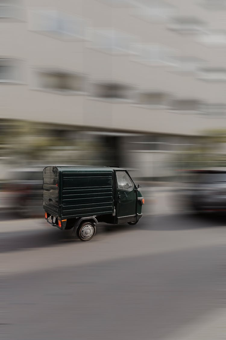 Piaggio Ape Car Driving Down City Street