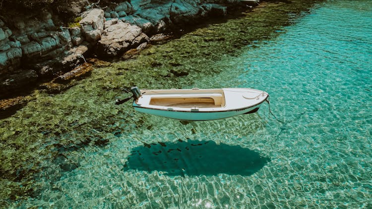 Boat Moored On The Shore In Clear Turquoise Water 