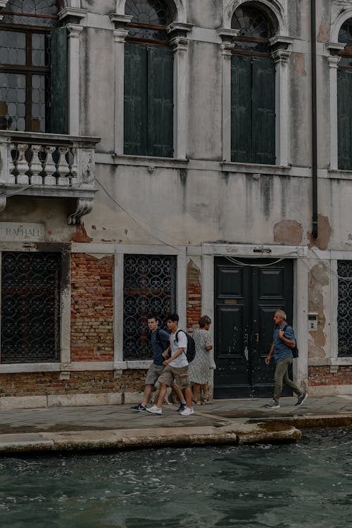 People Walking on a Pavement between the Building and the Canal in Venice, Italy 