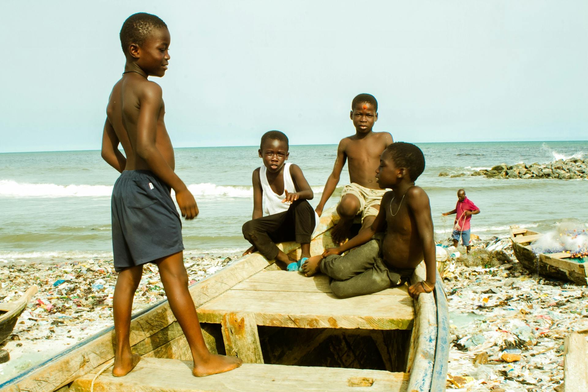 A group of African boys enjoying a sunny day on a fishing boat by the sea. Perfect for travel and lifestyle themes.