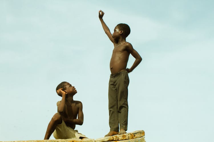 Two Young Boys Hanging Out Outdoors In Summer