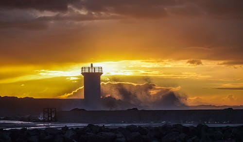 Lighthouse on Sea Coast at Sunset