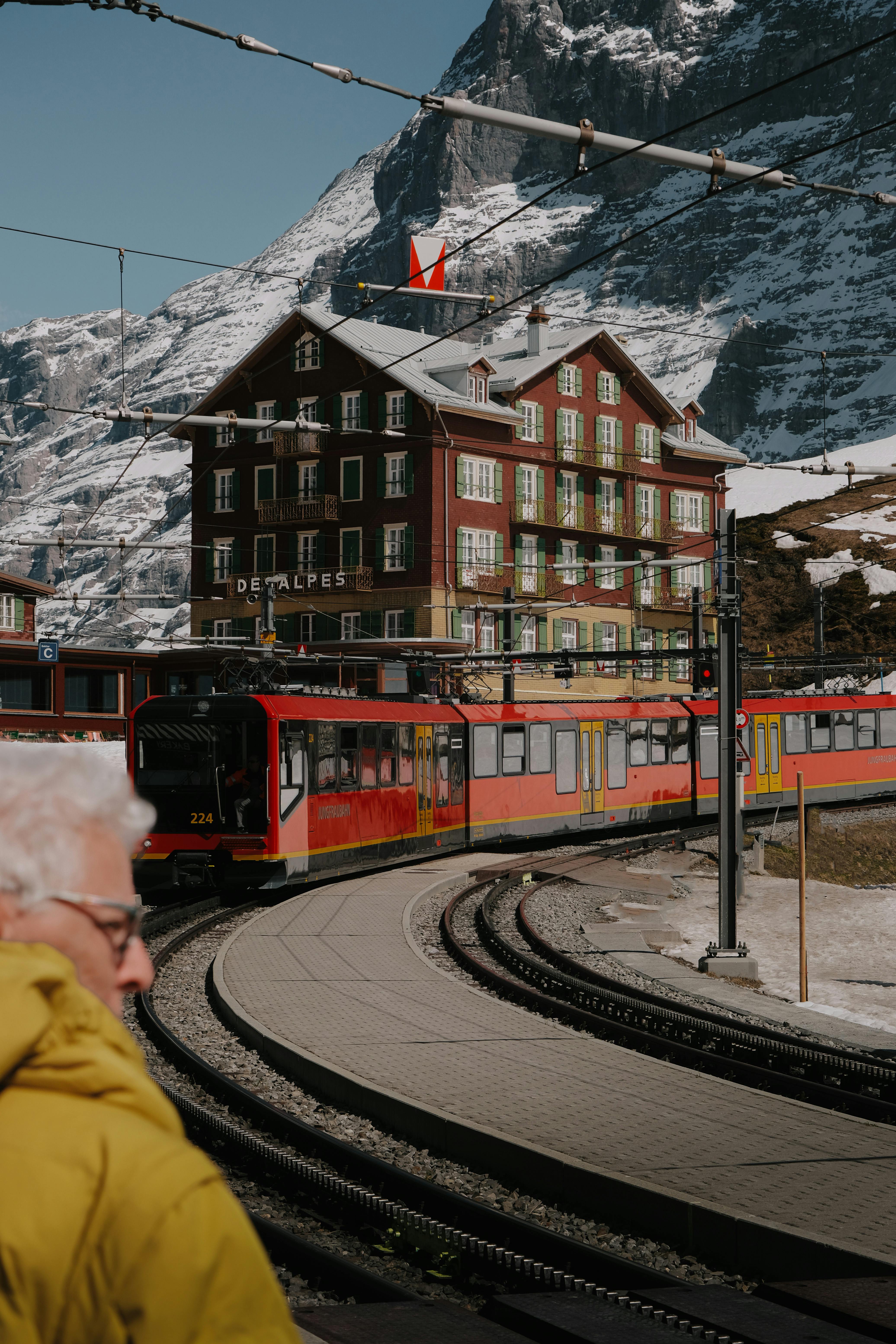 tram riding in front of a hotel in a mountain valley in switzerland