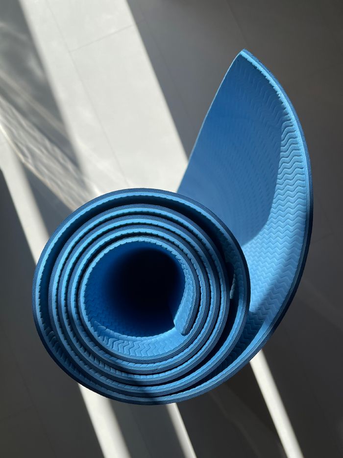 Rolled blue exercise mat in sunlight — photo by Vitalii Abakumov on Pexels