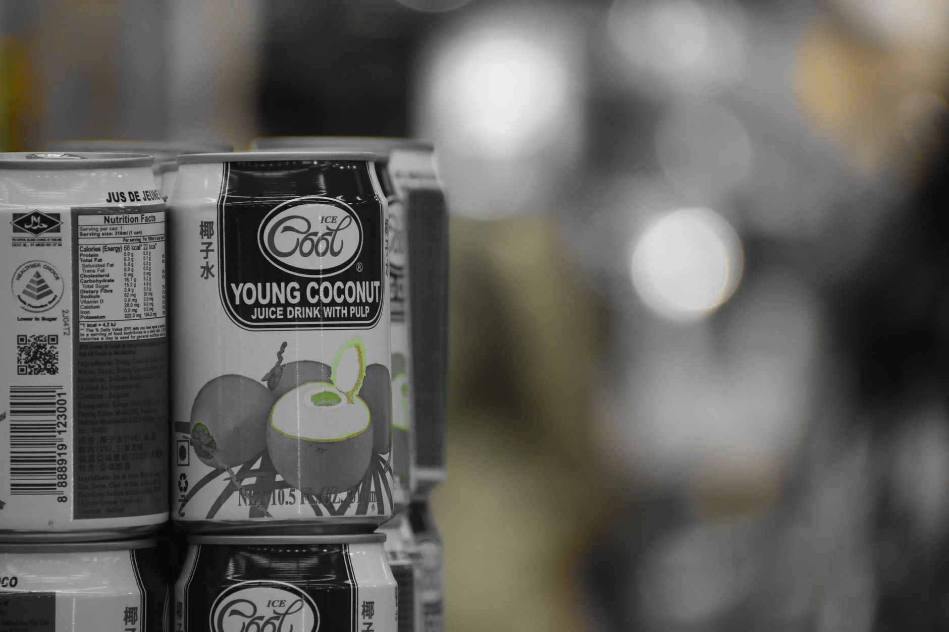 A stack of young coconut juice cans on a shelf with a retail background.