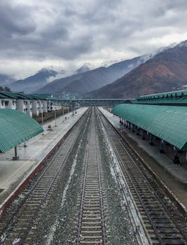 A scenic view of Banihal railway station with mountain backdrop. Captured on a cloudy day.