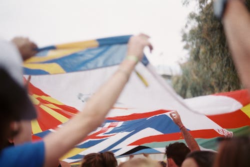 Close-up of People Walking in a Parade with Flags