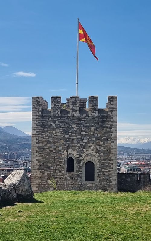 Free Majestic view of Skopje Fortress tower with Macedonian flag against a clear blue sky. Stock Photo