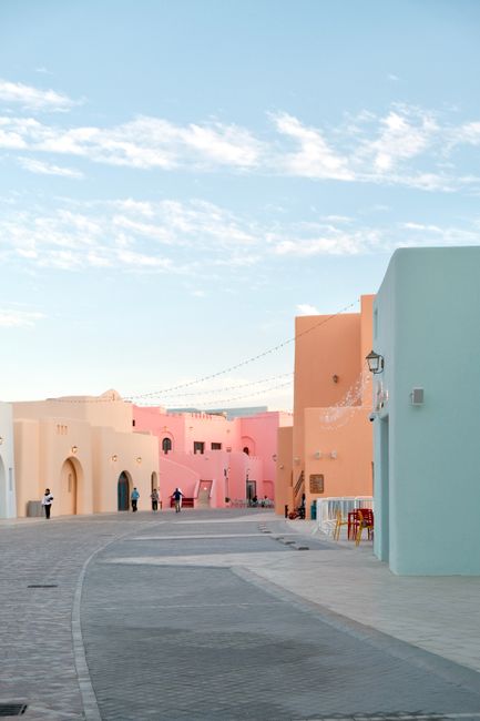 Vibrant pastel buildings lining the street in Katara Cultural Village, Doha, Qatar.