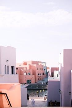 Vibrant pastel-colored buildings by a waterfront, creating a serene urban scene.