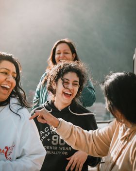 Group of women smiling and enjoying a moment together outdoors in Rishikesh, India.