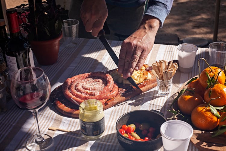 Man Slicing Food On A Cutting Board