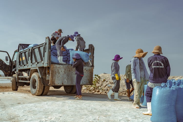 Men Unloading Bags From Truck