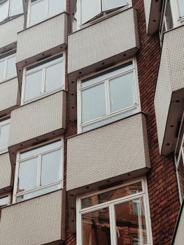 Close-up view of a modern apartment building showcasing architectural details and glass windows.