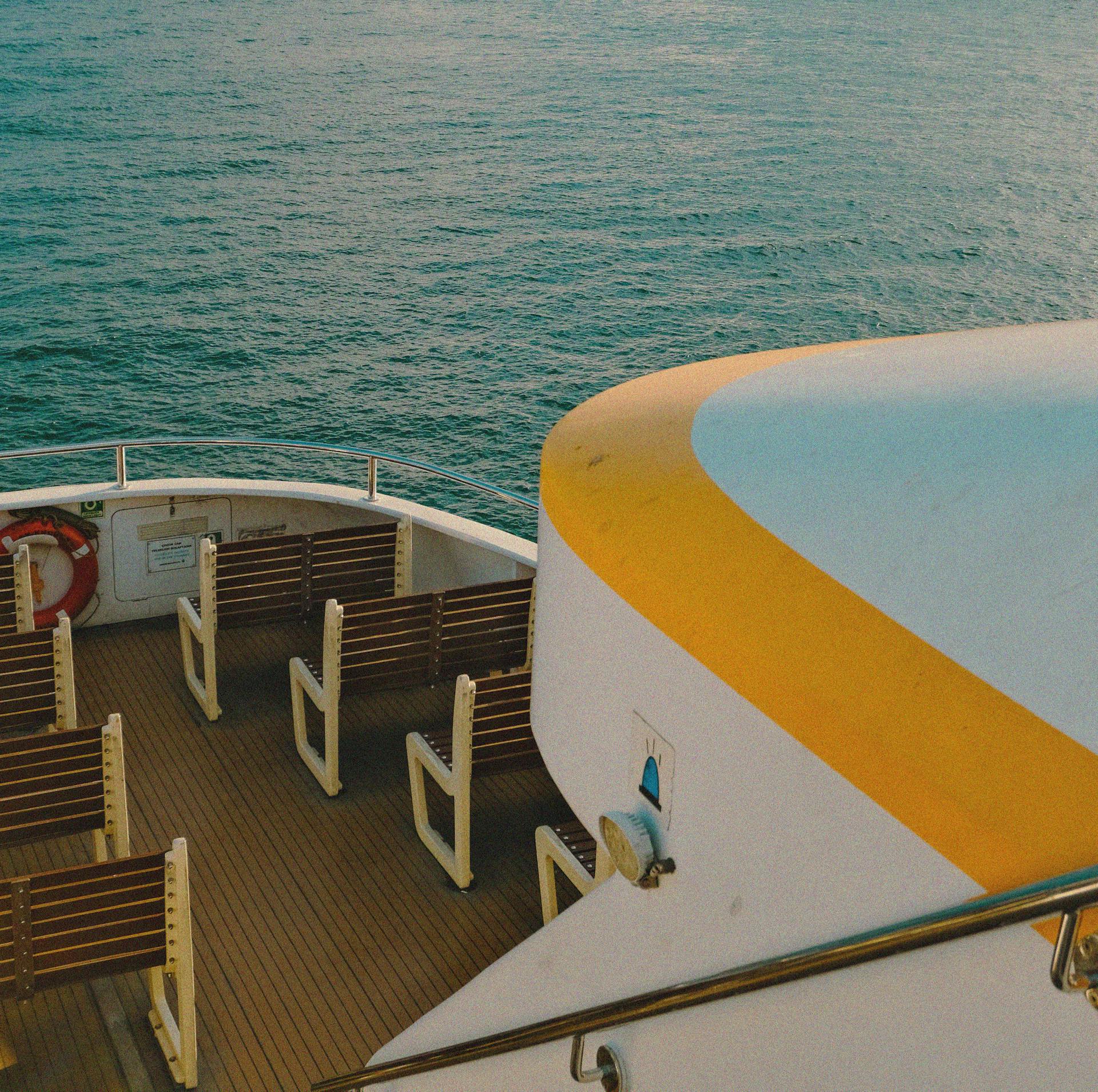 A luxury cruise ship deck with wooden seats and calm sea view, perfect for summer travel.