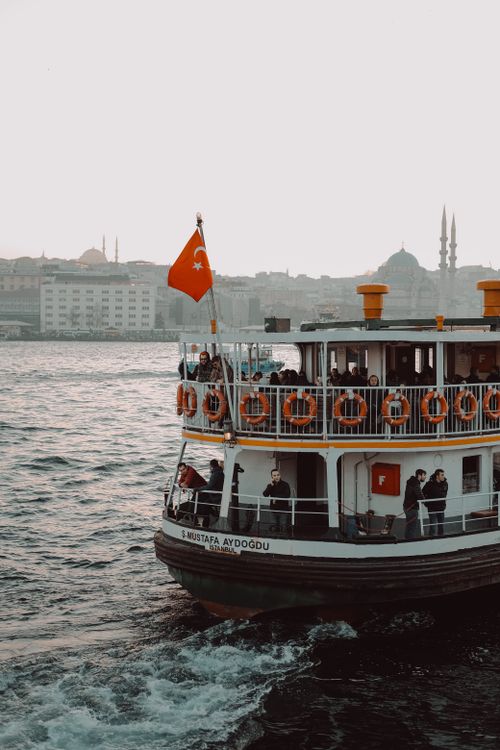 Free Experience a picturesque ferry journey on the Bosphorus with Istanbul's skyline and Turkish flag. Stock Photo