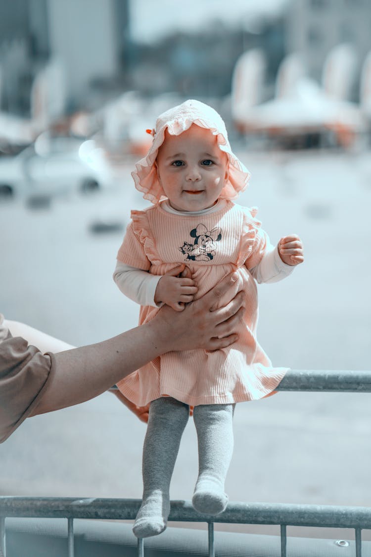 Hand Of Parent Holding Daughter On Railing