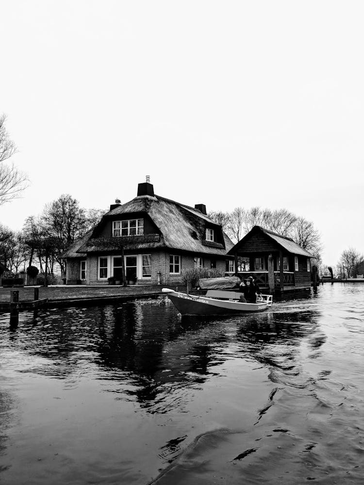 House On Riverbank In Black And White