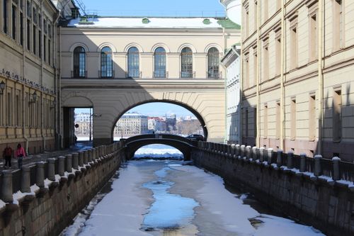 Free Beautiful winter canal scene featuring historic architectural arches in a European city. Stock Photo