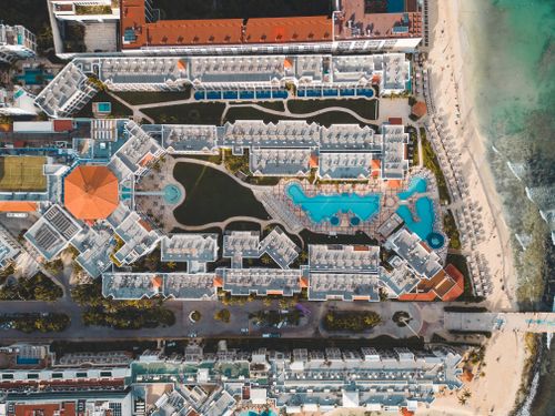 Free Stunning aerial view of a luxury resort in Playa del Carmen, featuring pools and beach access. Stock Photo