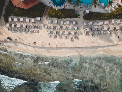 Free Aerial shot of a beachfront resort in Playa del Carmen, showing sun loungers, beach, and ocean. Stock Photo