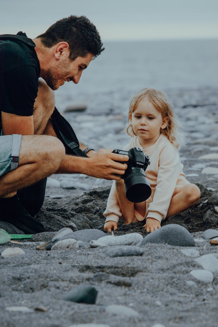 Father Showing Camera To Daughter