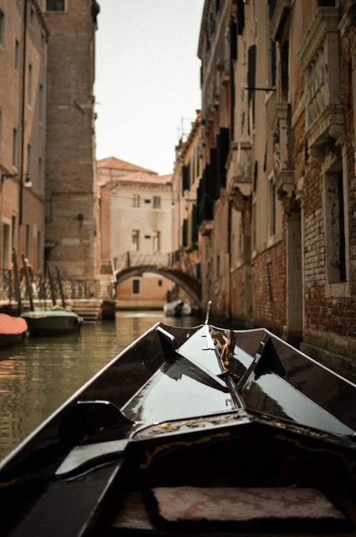 View of the Buildings and a Bridge from a Gondola in a Canal in Venice, Italy 